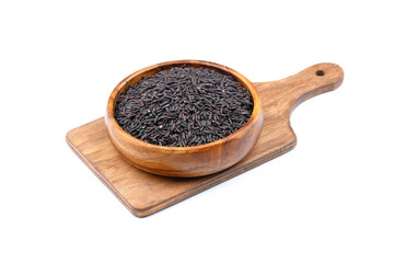 pile of black rice in a wooden bowl isolated on a white background.