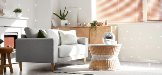 Interior of modern living room with grey sofa and disco ball on coffee table