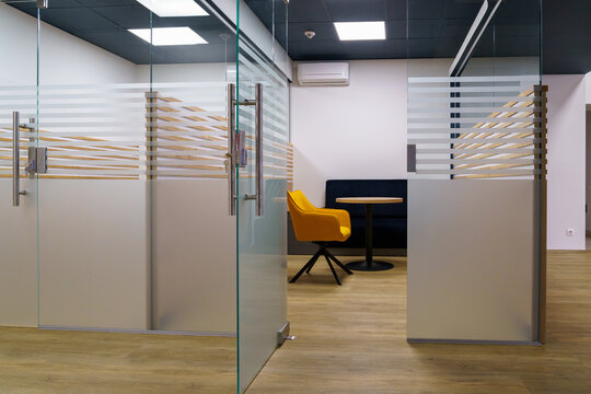 Modern office with glass partitions and stylish seating area