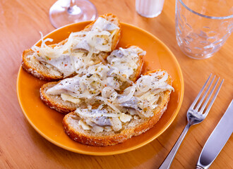 Appetizing sandwich with herring fillet and butter served on plate