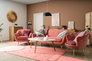 Cozy sofa, armchairs and coffee table in interior of living room