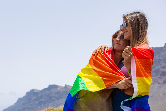 Embracing LGBTQIA pride with vibrant rainbow flag outdoors
