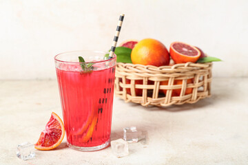 Glass of tasty blood orange lemonade on light background