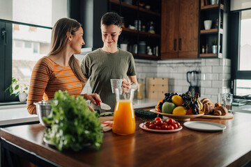 Lesbian couple preparing together healthy breakfast in modern kitchen