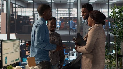 African american executive staff are engaged in administrative tasks, reviewing analytics reports...