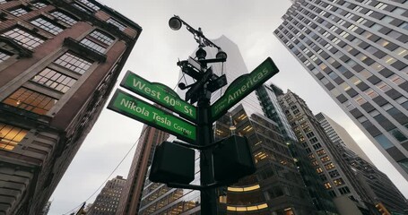 Street signs in New York at Nikola Tesla corner on rainy day. Intersection of West 40St And Avenue of Americans