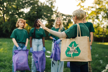 Group of people volunteering for cleanup picking up trash in park