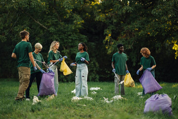 Group of people volunteers collecting rubbish in park