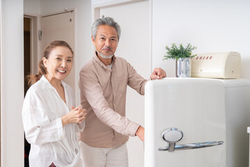 Fototapeta premium 冷蔵庫の中を見るシニアカップル