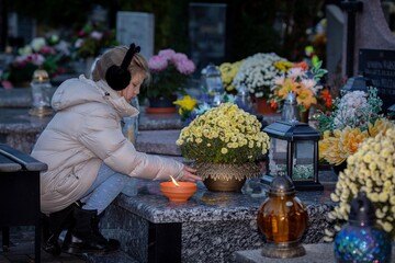 A Child Lighting a Candle at a Grave Surrounded by Beautiful Flowers in Peaceful Autumn