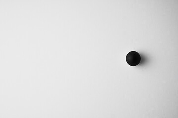 Minimalistic black sphere on a white surface, emphasizing simplicity and modern design aesthetics