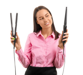Female hairdresser with curling iron and flattening iron on white background