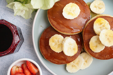 Tasty pancakes with honey and banana  on white background