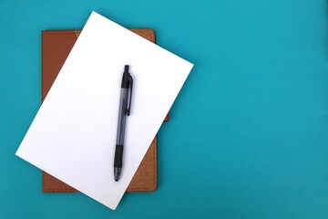 White paper and pen on blue table