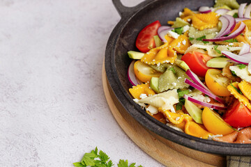 Frying pan with delicious Italian pasta salad on light background