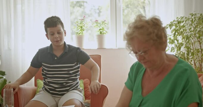 A heartwarming scene of a grandmother knitting while her grandson draws, showcasing family connection and inter generational bonding.