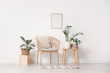 Interior of light room with armchair, table and green plants