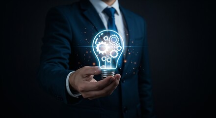 A businessman in a formal suit holds a glowing holographic light bulb representing innovation, technology, and modern ideas. The concept reflects creative thinking and advancement in business 