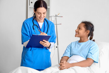 Teenage African-American girl with doctor in hospital room