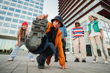 Energetic Breakdancer Showcasing a Skillful Freeze Move while Friends Support and Cheer him on...