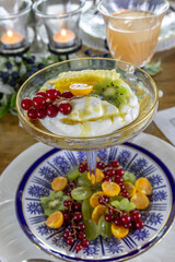 Fruit and Greek Yogurt breakfast with a slice of honey comb and golden berries