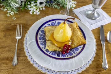 Pear poached in champagne and ginger on passionfruit curd and a puff pastry