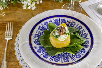 Stuffed Pear on a bed of spinach with a pecan nut on a bed of goat cheese