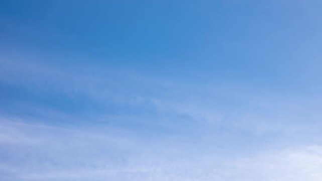 White clouds moving fast from right to left time-lapse. Daylight cloudy heaven background. Long timelapse light clouds transforming in blue sky with motion blur. Perfect for text, titles, logo