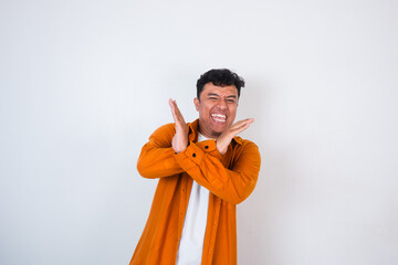An adult Asian man crosses his arms in front of his chest with a disapproving expression, as if...