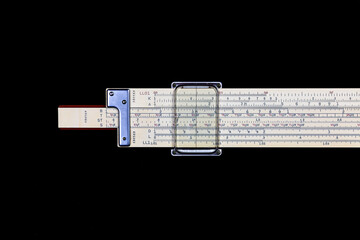 Closeup, engineers slide rule, circa 1950a. Made with yellow plastic. Black background. 
