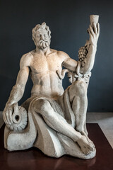 A statue of a man holding a wine glass