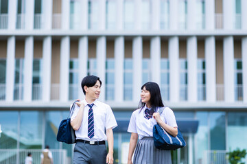 学校の前を歩く男女