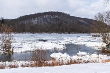 A frozen Allegheny River with large ice chunks in Tionesta, Pennsylvania, USA on an overcast winter...