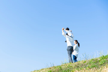 青空のもと、笑顔で歩く親子4人