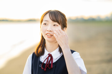 夕陽に包まれるアジア人女性の高校生