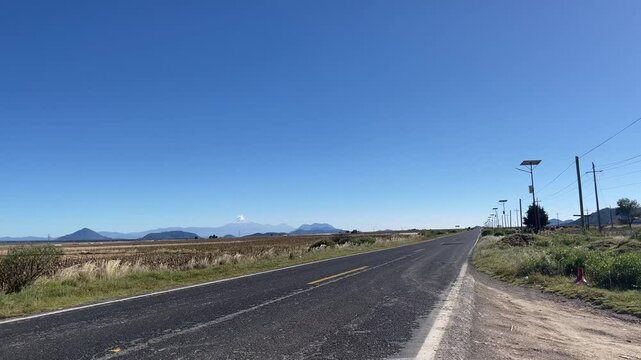 Empty highway in Mexico with "pico de orizaba" volcano in the background