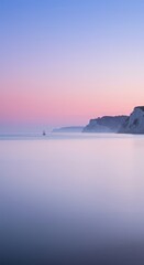 Fototapeta premium Tranquil seascape with distant sailboat at sunset by majestic cliffs