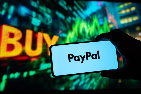 PayPal Holdings Logo app on the screen of a phone, smartphone application, green stock market background going up, button spelling &ldquo;BUY&rdquo;, online Money transfers, Puebla, Mexico, December 22, 2024