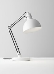 White adjustable desk lamp with metal arm and dome shade on white surface.