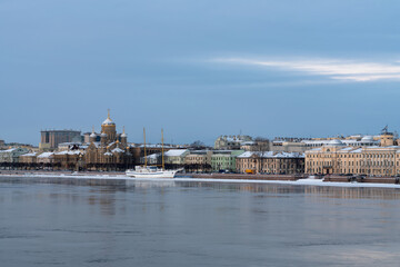 Obraz premium Embankment of Lieutenant Schmidt and the Church of the Assumption of the Blessed Virgin Mary (Assumption Church) on the banks of the Neva River on a winter day, Saint Petersburg, Russia