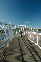 a woman with blonde hair, wearing a hat, was walking and enjoying the beauty around the Whangarei Town Basin