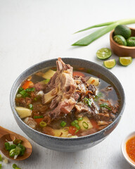 Enjoy a flavorful meat soup filled with tender meat, fresh vegetables, lime, and a vibrant dipping sauce, perfect for sharing