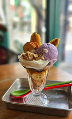 Thai style sweet potato homemade ice cream serving with wiped cream, chestnut, cracker, and banana