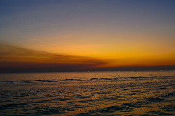 sunset in the sea. Beautiful colorful sky and cloud in twilight time background. Orange fluffy clouds and sun sunlight reflection in the blue sky. 