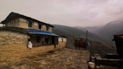 Traditional Mud & Brick house with open courtyard with overcast Himalaya mountains in the...