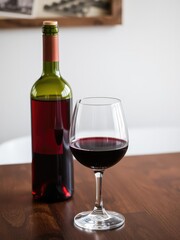 Bottle and glass of red wine on wooden table, fancy, celebration