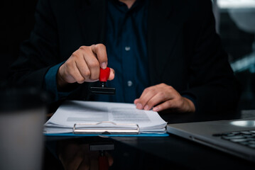 Business holding rubber stamp document approval verification. Corporate executive legal papers with...