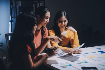Business people working late at laptop in highrise office