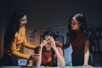 Business people working late at laptop in highrise office
