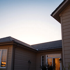 Modern House Exterior: Architectural Design and Sunset View.  High-quality image showcasing the home's design, roofline, and exterior finishes at sunset.